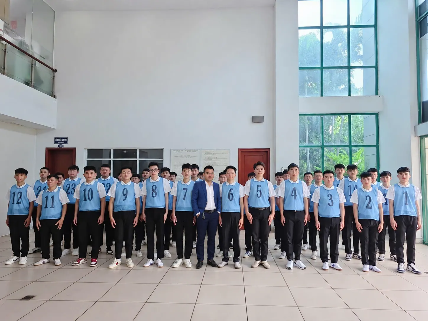 Đức Nguyễn, Trưởng phòng Tuyển dụng SIMCO Sông Đà, đứng giữa các ứng viên đeo áo số chờ phỏng vấn đơn hàng cơ khí Đài Loan